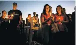  ?? SAUL MARTINEZ THE NEW YORK TIMES ?? Members of the community attend a vigil Thursday to honor the victims of the shooting at Marjory Stoneman Douglas High School in Parkland, Fla.