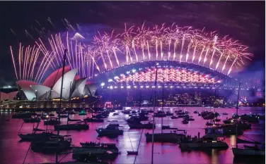  ?? (AP/Mark Baker) ?? Fireworks explode over the Sydney Opera House and Harbour Bridge in celebratio­n of the new year Thursday in Sydney, Australia.