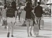  ?? Lynne Sladky / Associated Press file ?? Tourists carry shopping bags in Miami Beach, Fla. The U.S. gross domestic product started slow in 2017.