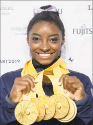  ?? Marijan Murat / Associated Press ?? Simone Biles shows her five gold medals at the Gymnastics World Championsh­ips in Stuttgart, Germany on Sunday.