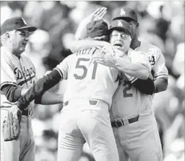  ?? Mark Lennihan Associated Press ?? BRIAN HOLTON hugs manager Tommy Lasorda as pitching coach Ron Perranoski, left, looks on after holding off the New York Mets in 1988 playoff game.