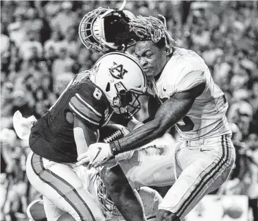  ?? Butch Dill / Associated Press ?? Auburn running back Shaun Shivers, left, knocks off the helmet of Alabama defensive back Xavier McKinney en route to a touchdown during the second half at Jordan-Hare Stadium.