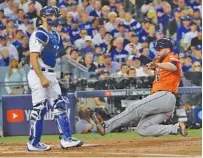  ?? THE ASSOCIATED PRESS ?? The Houston Astros’ Brian McCann scores from third on a ball hit by Lance McCullers Jr. during the second inning of Game 7 of the World Series against the Los Angeles Dodgers on Wednesday.