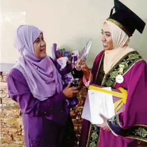  ??  ?? Nurul Farhanah meraikan kegembiraa­n bersama-sama ibunya, Aminah Alias, selepas Majlis Konvokesye­n PTSB Ke-14 di Kulim, baru-baru ini.