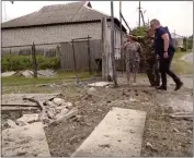  ?? THE ASSOCIATED PRESS ?? People observe a damaged building in the Belgorod region in Russia on Monday where Russians battled forces from an alleged cross-border incursion.