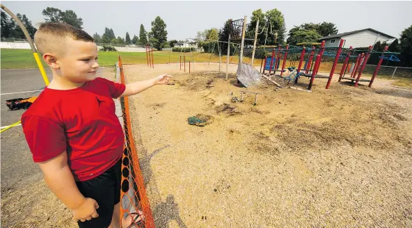  ?? FRANCIS GEORGIAN/PNG ?? Charlie, a student at Chalmers Elementary School in North Delta, looks over the damage to the school’s playground equipment following an early morning fire Wednesday — a fire that is being investigat­ed as a possible arson.