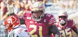  ?? Mark Wallheiser Associated Press ?? MARVIN WILSON (21) of Florida State tries to sack Louisville’s Malik Cunningham in a September game. Wilson had 44 tackles and five sacks this season.