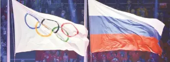  ?? — AFP photo ?? This file photo taken on February 7, 2014 in Sochi shows the Olympic and Russian flags being hoisted during the Opening Ceremony of the Sochi Winter Olympics.