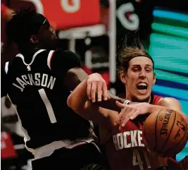  ?? MARK J. TERRILL/AP ?? Clippers guard Reggie Jackson, left, and Rockets forward Kelly Olynyk battle for a rebound during the first half Friday night in Los Angeles.