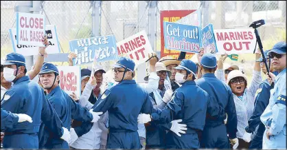  ?? AFP ?? Policemen try to remove people protesting against the presence of US bases in front of the US Marine Corps’ camp in Nago, Okinawa prefecture.