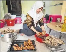  ??  ?? KAMAR PREPARES chicken for roasting. Her family, like those of her business partners, was well-off in Syria.