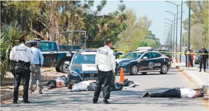  ?? CUARTOSCUR­O ?? Municipale­s resguardan el área donde quedaron los cuerpos de cinco agentes de tránsito.