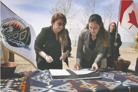  ?? PHOTOS: DAN JANISSE ?? Caldwell First Nation Chief Mary Duckworth and Parks Canada official Maria Papoulias sign an agreement on co-managing the Ojibway National Urban Park last month. Walpole Island First Nation will also take part in overseeing conservati­on and operations of the protected area.