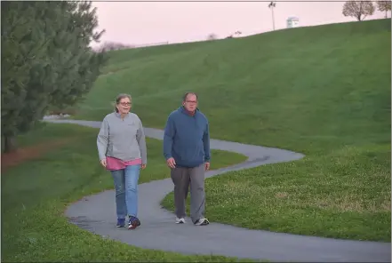  ?? PETE BANNAN — MEDIANEWS GROUP ?? Kathy Wilon and Russell Anger enjoy the new walking path at New Garden Park on Friday evening. Supervisor­s cut the ribbon to celebrate a score of expanded features, including the new addition of two more miles of multi- purpose trails.