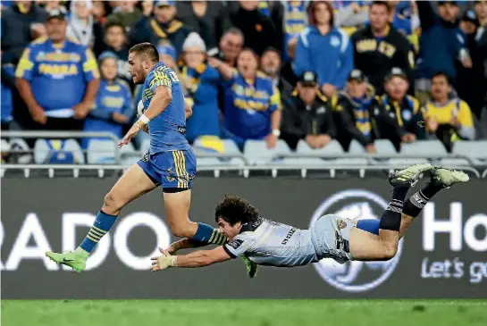  ?? PHOTO: GETTY IMAGES ?? Will Smith of the Eels makes a break and beats the tackle of Jake Granville of the Cowboys to score a during the NRL semifinal in Syndey.