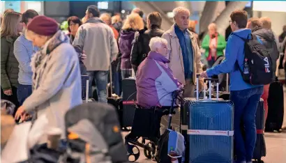  ?? AFP AFP ?? Travellers wait for a bus after flight cancellati­ons during a one-day strike by security staff at Stuttgart’s airport on Thursday. —