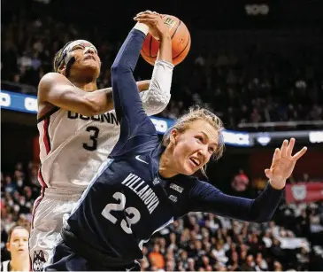  ?? Jessica Hill/Associated Press ?? UConn’s Aaliyah Edwards (3) and Villanova’s Maddie Burke tangle for a rebound during the first half of the Big East championsh­ip game on Monday at the Mohegan Sun Arena in Uncasville.