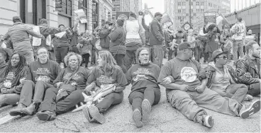  ?? Teresa Crawford / Associated Press ?? Protesters block traffic outside Chicago’s Willis Tower, where United was having its shareholde­rs meeting.