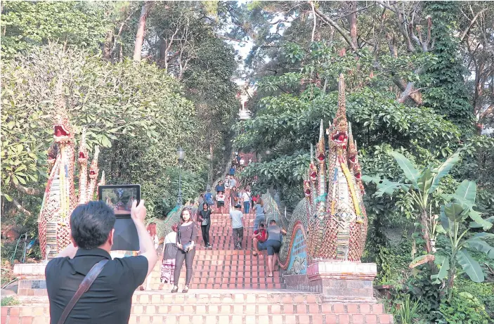  ??  ?? MIND YOUR STEP: Dokmai and Gaolhee greeted and performed dances for visitors at the popular Doi Suthep every day after school until a viral incident questioned their integrity.