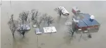  ?? PHOTOS: AP ?? Under water . . . Flooding along the Missouri River in Pacific Junction, Iowa. The US Army Corps of Engineers says rivers breached at least a dozen levees in Nebraska, Iowa and Missouri. Hundreds of homes are damaged, and tens of thousands of hectares are under water.