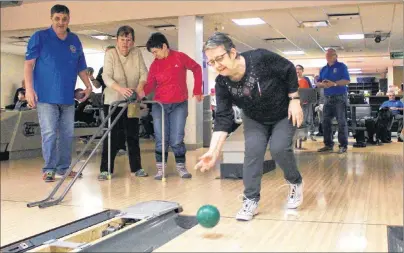  ?? MILLICENT MCKAY/JOURNAL PIONEER ?? Sandra Poirier, centre, bowls as participan­ts of the annual bowling event to mark White Cane Week watch.