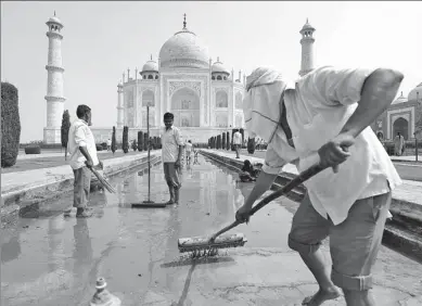  ?? SAUMYA KHANDELWAL / REUTERS ?? Laborers clean the fountain in the historic Taj Mahal premises in Agra, India, on Saturday.