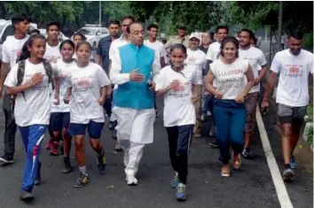  ?? — PTI ?? Union sports minister Vijay Goel with wrestler Babita Phogat take part in a “Slum Yuva” marathon at Rohini in New Delhi on Saturday.