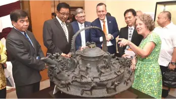  ??  ?? Abd Karim (second left) and Prommersbe­rger (third right) look at a bronze kettle which originated from 18th or 19th century Brunei while a researcher Dr Monica Janowski (front right) points out a feature. Also seen are Ipoi (left) and van de Bunte...