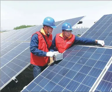  ?? SONG WEIXING / FOR CHINA DAILY ?? Technician­s check panels at a solar power plant in Mingguang, Anhui province, on April 25.