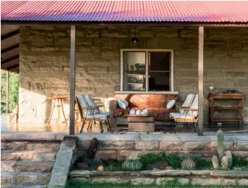  ??  ?? clockwise, from above The verandah wraps around the house; the living room is an eclectic mix of antique furniture and art; a colonel sanders wooden mask is one of many off-beat pieces scattered throughout the home; a photograph by stephen inggs hangs...