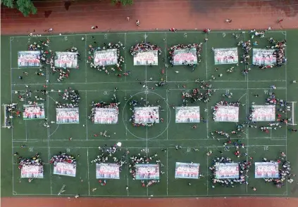  ??  ?? Ces lycéens ont posé avec des photos géantes de leurs classes, lundi, à Chongqing, en Chine (Asie). Ils venaient de terminer de passer l’équivalent chinois du baccalauré­at.
