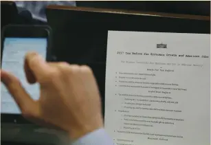 ?? (Carlos Barria/Reuters) ?? A REPORTER takes a picture of a White House press release on its tax-reform plan during the daily briefing at the White House in Washington on Wednesday.