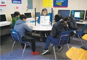  ?? NELVIN C. CEPEDA U-T PHOTOS ?? Selena Hernandez, a bilingual instructio­nal aide at Oak Crest Middle School in Encinitas, works Thursday with her seventh- and eighth-grade students in small groups called learning pods.