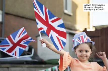  ??  ?? Aaliyah Omar waves a Union Jack flag at a street party in Cardiff
