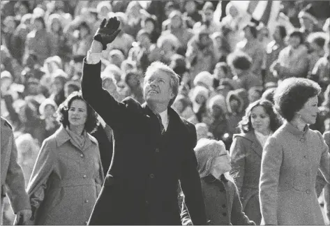  ?? AP PHOTO/SUZANNE VLAMIS ?? U.S. President Jimmy Carter waves to the crowd while walking with his wife, Rosalynn, and their daughter, Amy, along Pennsylvan­ia Avenue.