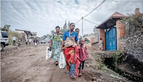  ??  ?? GOMA residents carry their belongings as they hurry to leave the city after an evacuation order was given yesterday. The authoritie­s in Goma, in the east of the Democratic Republic of Congo (DRC), yesterday ordered the evacuation of part of the city because of the risk of eruption of the Nyiragongo volcano. | AFP