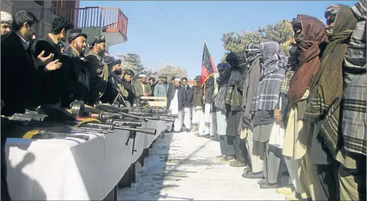  ?? CATERS/RAHMINE/XINHUA PRESS/CORBIS ?? Taliban fighters attend a weapons surrender ceremony in the province of Ghazni. Elsewhere, in Sar-e Pol around 200 ‘reformed insurgents’ have been found to be imposters seeking cash handouts