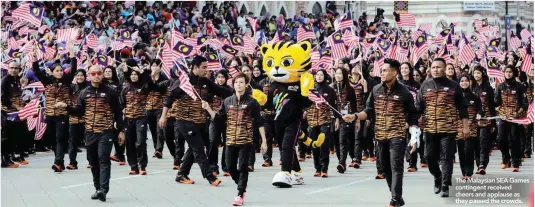  ??  ?? The Malaysian SEA Games contingent received cheers and applause as they passed the crowds.