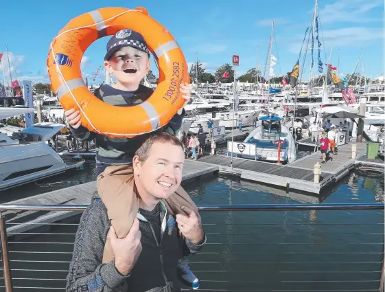  ?? Picture: GLENN HAMPSON ?? Paul Gillett, of Narangba, keeps son Cian, 5, happy and safe at the Sancturay Cove Internatio­nal Boat Show yesterday.