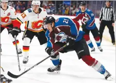  ?? Associated Press photo ?? Colorado Avalanche center Nathan MacKinnon, front, loses control of the puck in front of Calgary Flames left wing Johnny Gaudreau during the first period of an NHL hockey game Wednesday.