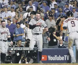  ?? Robert Gauthier Los Angeles Times ?? CARLOS CORREA pounds his chest as he awaits Marwin Gonzalez after his homer in the ninth inning of Game 2. Correa has been soliciting donations for Puerto Rico after Hurricane Maria.