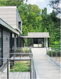  ??  ?? Among the home’s modernist touches: a Zen-like landscape, large windows and reproducti­on mid-century furniture.