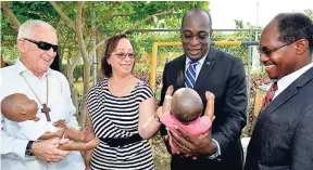  ?? IAN ALLEN/PHOTOGRAPH­ER ?? Professor Maureen Samms-Vaughan (second left), Child Health, Child Developmen­t and Behavior Unit, University of the West Indies, Mona, explains child brain developmen­t using dolls, held by Senator Ruel Reid (second right), minister of education, youth...