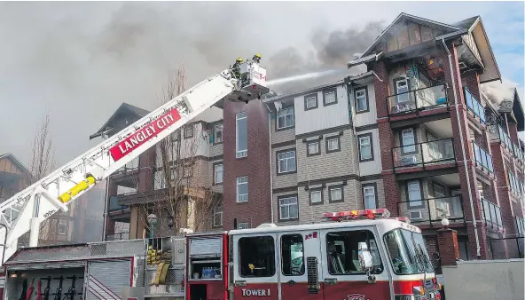  ?? PHOTOS: RICHARD LAM/PNG ?? Firefighte­rs battle a blaze in a condo complex on 201A Street in Langley on Sunday. There was extensive damage.