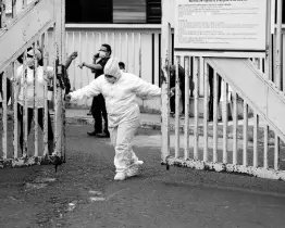  ?? AP ?? A health worker in protective gear to protect himself from COVID-19 closes the principal door of the coronaviru­s unit at San Juan de Dios Hospital in Guatemala City on Tuesday.