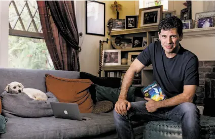  ?? Christina Gandolfo / New York Times ?? Max Brooks, whose latest book is “Minecraft: The Island,” sits with his dog, Milo, at their home in Los Angeles.