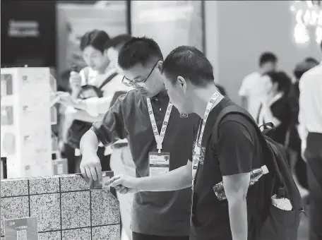  ?? PROVIDED TO CHINA DAILY ?? Visitors gather at Nippon Paint China’s booth during an industry fair in Shanghai in August. The Singapore-based Nipsea Group is the parent company of Nippon Paint China.