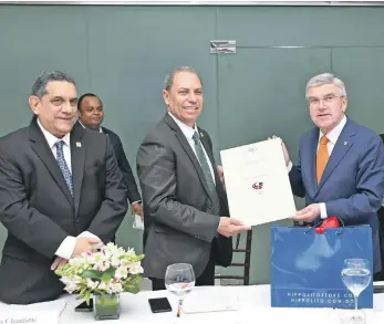  ?? ?? Thomas Bach entrega un certificad­o a Garibaldy Bautista, que acredita a la institució­n como mimebro del Comité Olímpico Internacio­nal. Observa Luis Chanlatte.