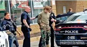  ?? ?? A man is detained following a mass shooting in the parking lot of TOPS supermarke­t (REUTERS)