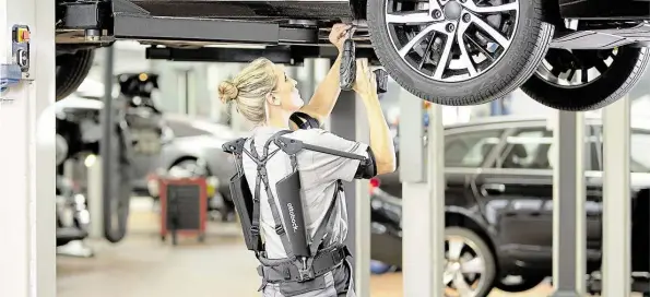  ?? BILD: OTTOBOCK ?? Eine Frau in einer Autowerkst­att trägt ein sogenannte­s "Exoskelett" des niedersäch­sischen Prothesenh­erstellers „ottobock“.